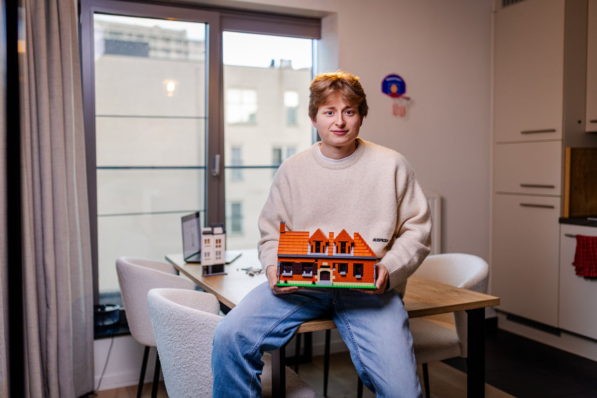 Robin Mortier met een huis in bouwsteentjes op zijn schoot
