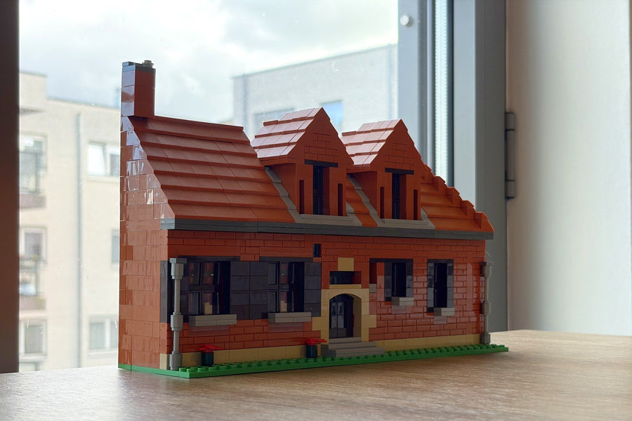 Hetzelfde landhuis, echt gebouwd in bouwsteentjes, op een vensterbank