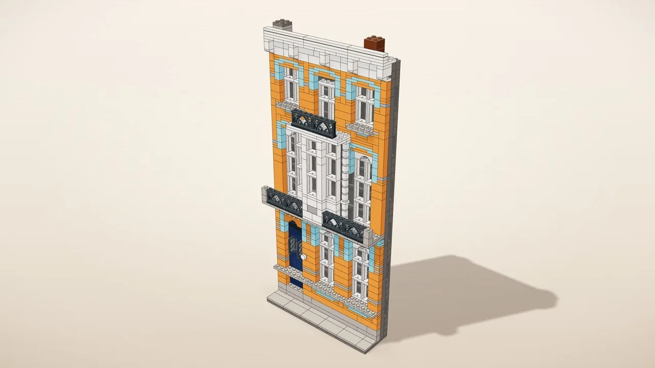 Facade kit: the front of a house in building bricks on a base with a front garden, next to a coffee mug
