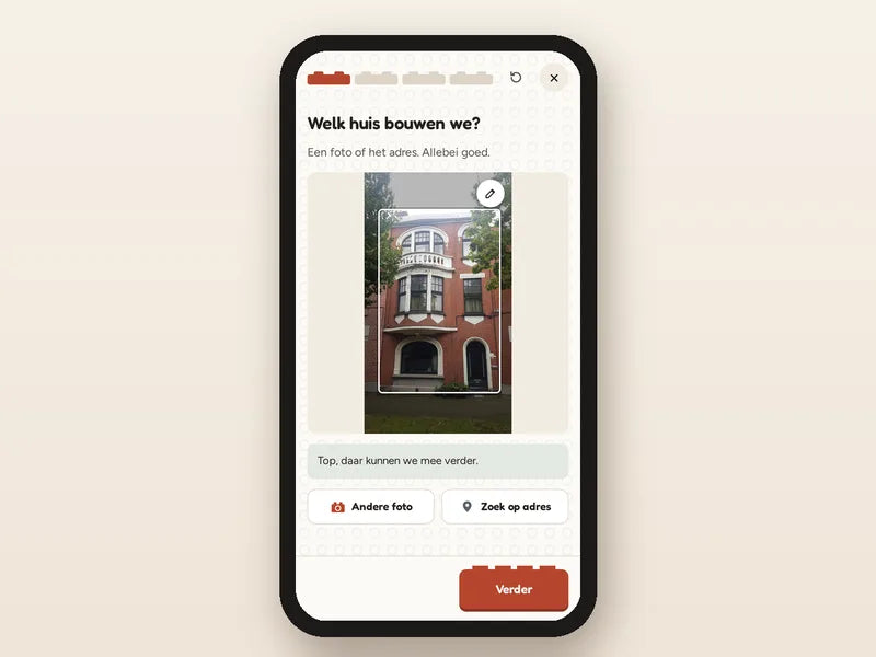 Telefoon met de OurBricks-studio: de foto van een rijwoning is geüpload om het in blokjes te ontwerpen